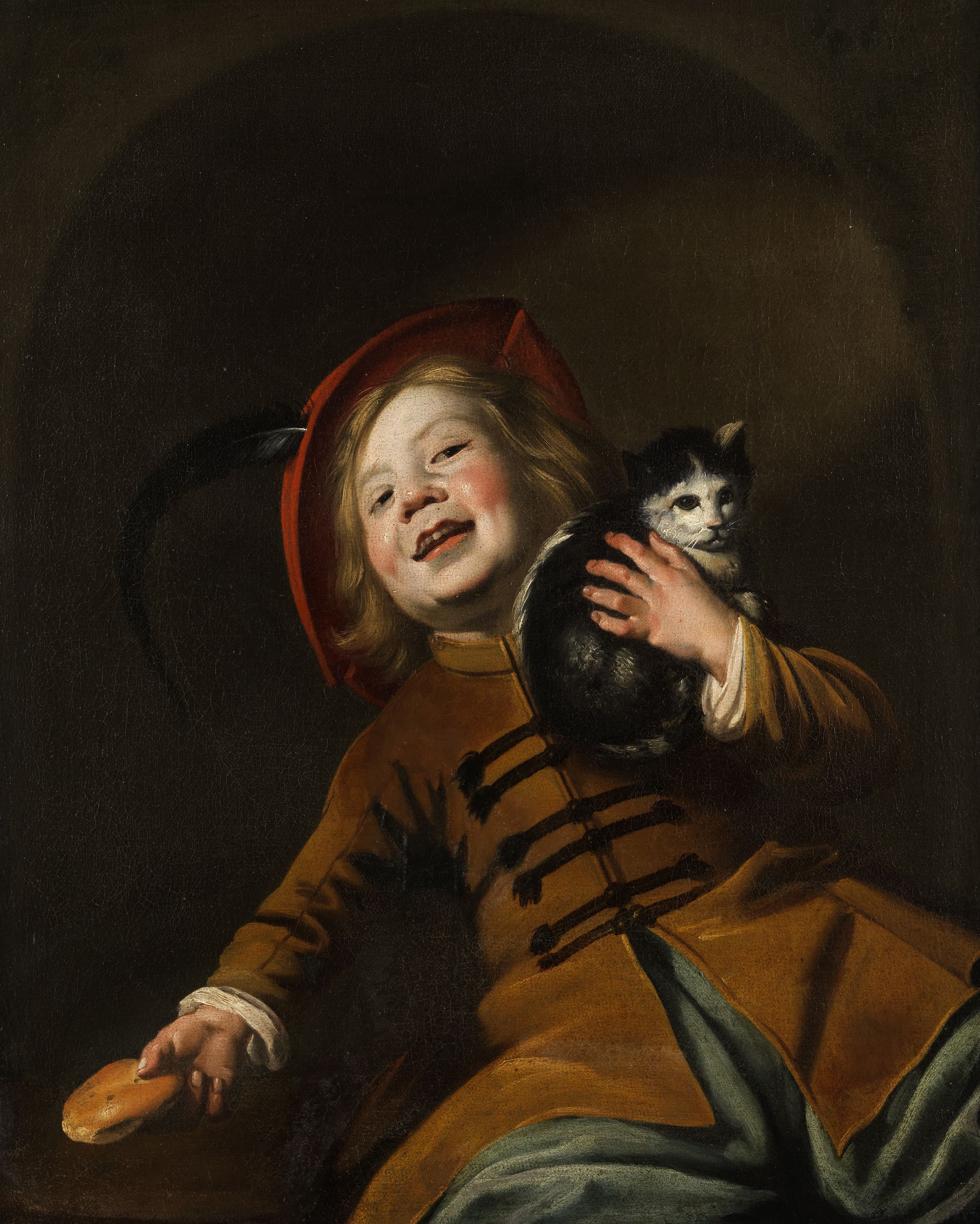 Boy with a cat, red hat and a piece of bread